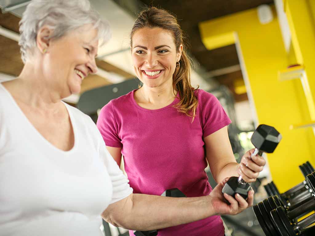 Fitness trainer working with a client with dumbbells